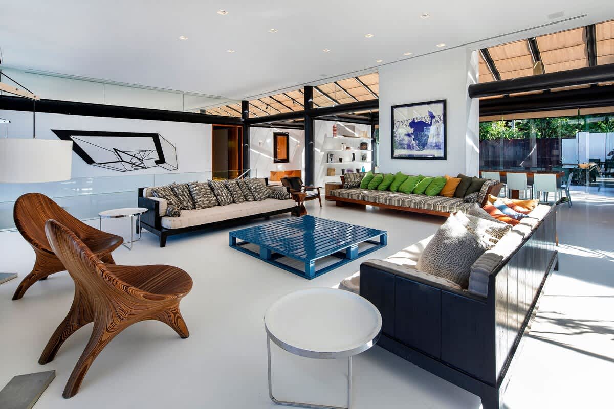 Open-plan living pavilion with custom Brazilian chairs and large-scale art.